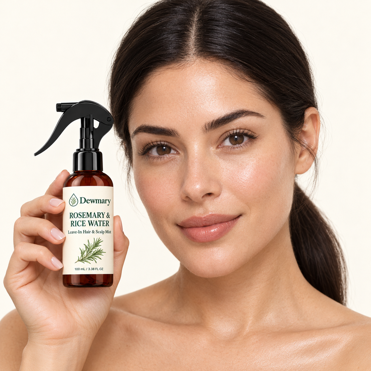 Smiling woman with her hair pulled back in a ponytail, holding Dewmary spray